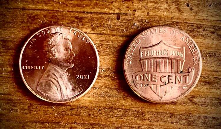 Grading strip showing four 2021 Lincoln pennies from worn to gem uncirculated condition